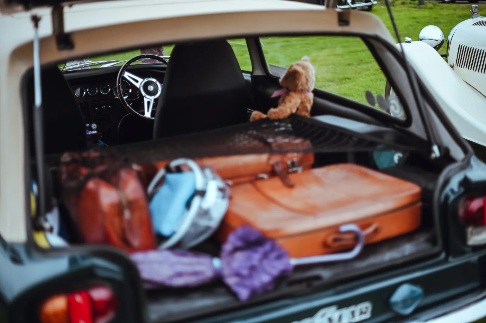 Person loading luggage into a car trunk before auto transport