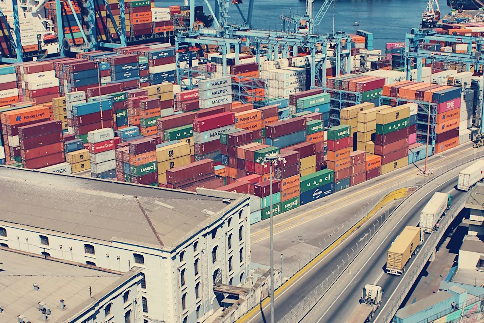 Container terminal cranes and stacked shipping containers illustrating seaport freight logistics like the Port of Mobile